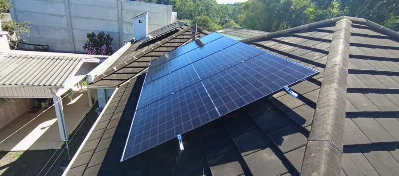 Detalhe dos módulos fotovoltaicos fixados sobre as telhas
